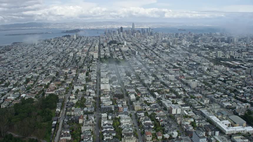  aerial footage showcasing the Inner Richmond neighborhood as the camera tilts up to reveal the stunning Downtown San Francisco skyline on a cloudy day in California capturing the high rise buildings and cityscape of this iconic city on the West Coast wit