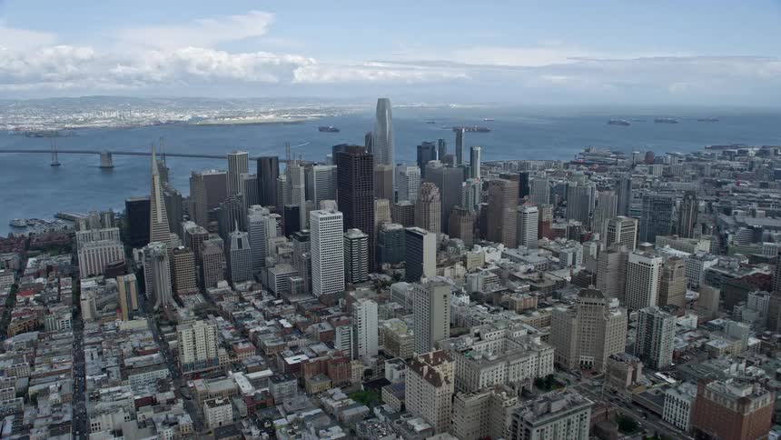  aerial footage of Downtown San Francisco California as seen from a high-rise building with approaching cloudy skies and iconic structures like the Transamerica Pyramid visible