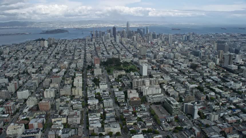 Aerial footage of downtown San Francisco skyline approaching from Pacific Heights California on a cloudy day showcasing high rise towers and cityscape in the beautiful Northern California bay area during spring/summer