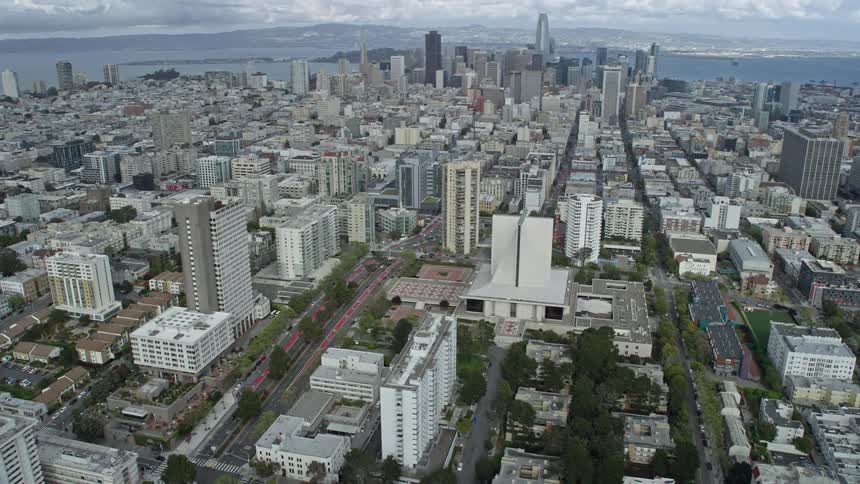 Aerial view of San Francisco's skyline and cathedral in Western Addition with cloudy skies and towering skyscrapers