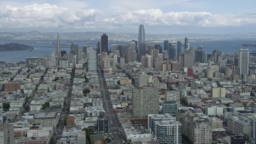  aerial footage of San Francisco's skyline featuring tall buildings a river in the background and cloudy skies
