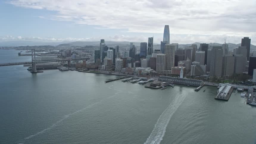 Aerial view of Downtown San Francisco's skyscrapers as the camera flies away capturing the city's magnificent skyline on a cloudy day