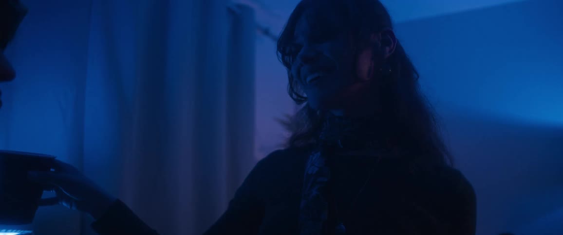 Teenager girls dancing and drinking indoors at a party in a living room during night time
