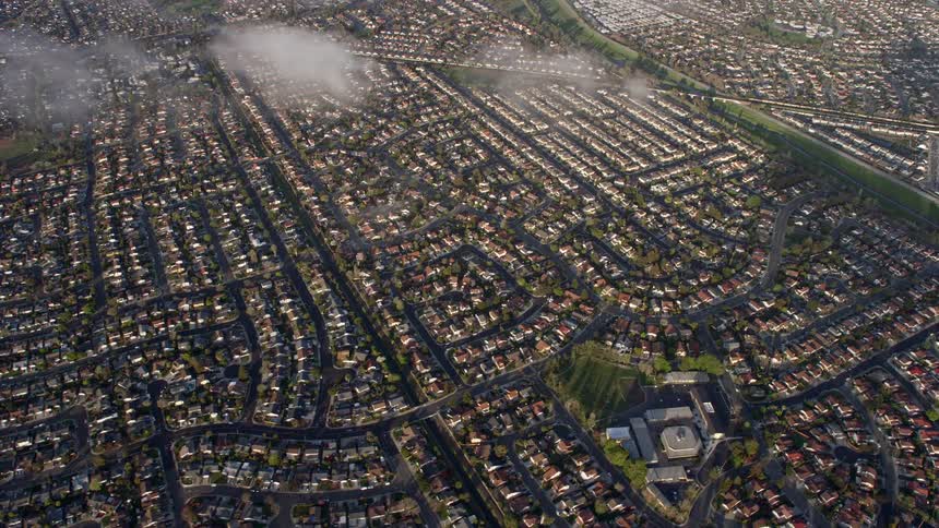  aerial footage showcasing a bird's eye view of tightly packed suburban neighborhoods in Union City California with partly cloudy skies and a tilt down perspective