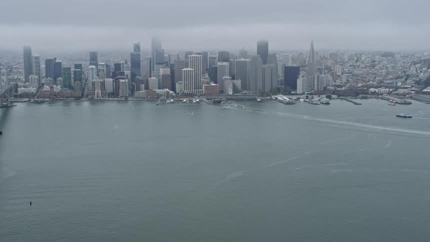Stunningaerial footage of Downtown San Francisco California showcasing the Bay Bridge cityscape and foggy atmosphere