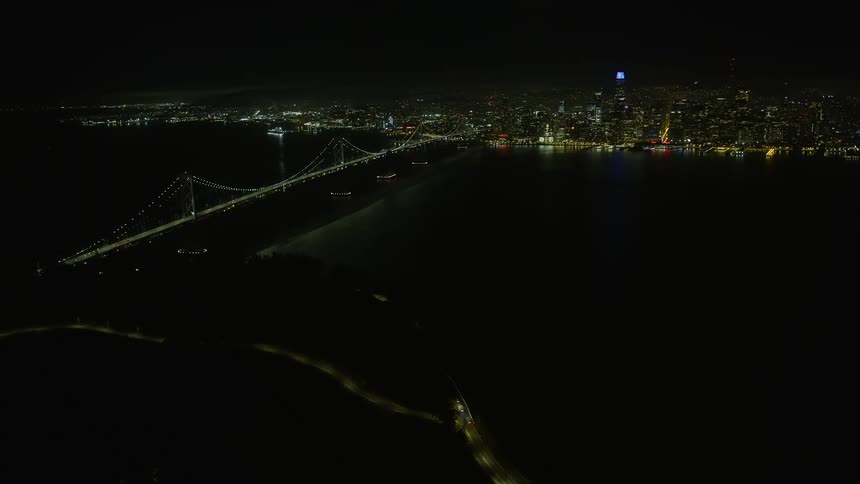  aerial footage capturing the breathtaking night view of the Bay Bridge downtown skyline and the illuminated cityscape of San Francisco California