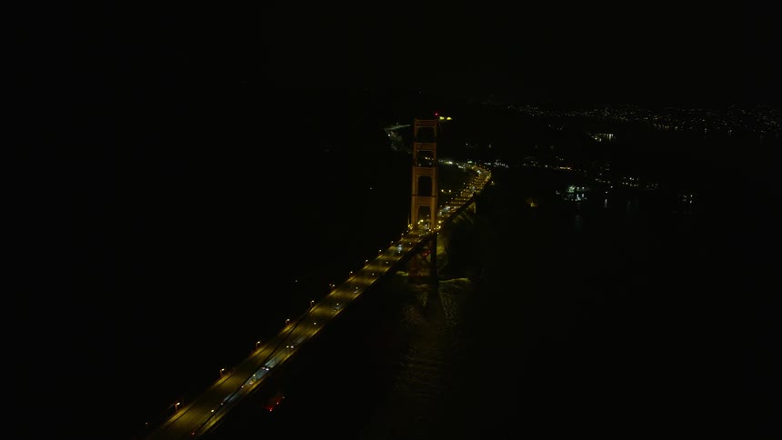Aerial footage of light traffic on the Marin side of Golden Gate Bridge at night with clear skies and headlights illuminating the iconic structure shotover withhelium camera during the spring/summer in the San Francisco Bay Area California