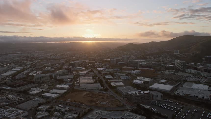  aerial footage showcasing an sunset behind office buildings in South San Francisco California with a partial view of the bay and stunning wide-angle shots captured using the Shotover F1 system