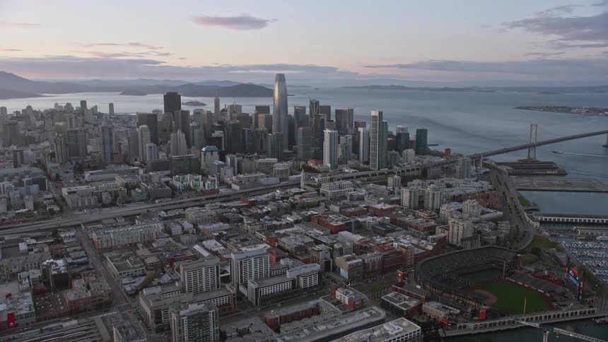  aerial footage captures the stunning San Francisco skyline at sunset showcasing high rise towers skyscrapers and the vibrant cityscape of downtown San Francisco from the South of Market area in Northern California