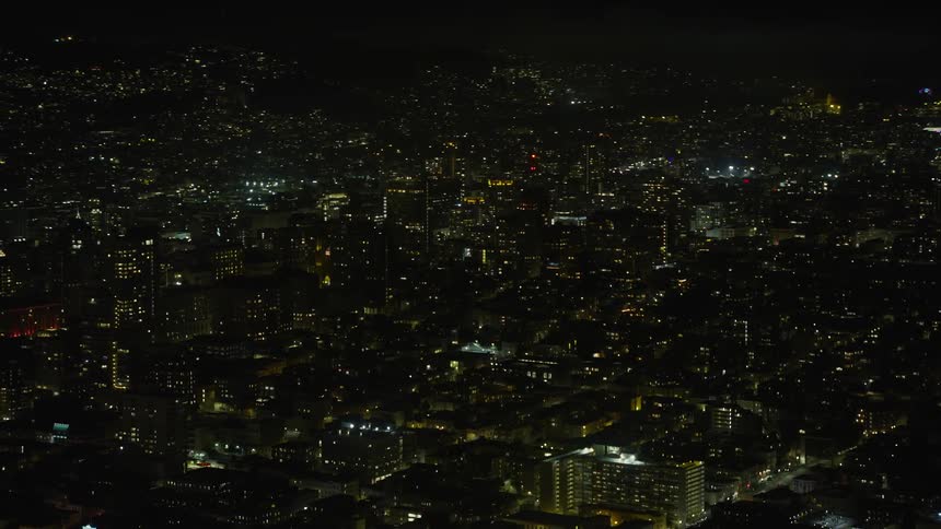 Aerial footage of Nob Hill apartment and office buildings at night in San Francisco California showcasing the city skyline of the metropolitan area