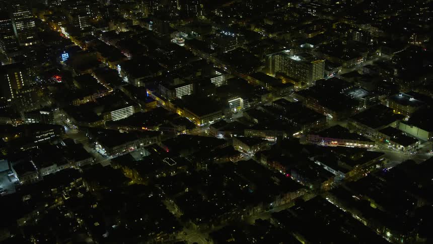 Aerial footage of illuminated city streets at night showing the intersection of Columbus Avenue and Broadway in North Beach San Francisco California