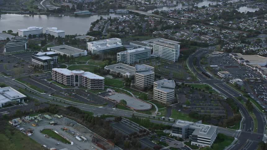  aerial footage ofsunset over Redwood City California flying past office buildings showcasing the industrial landscape of the Bay Area