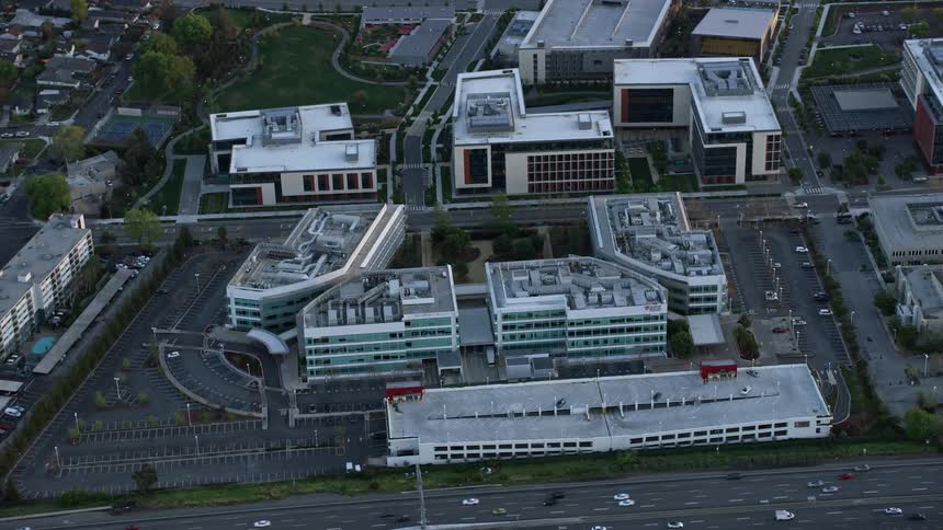  aerial footage captures the Stanford Medicine Outpatient Center at sunset in Redwood City California showcasing the bustling clinic against a backdrop of partly cloudy skies and the vibrant colors of the evening