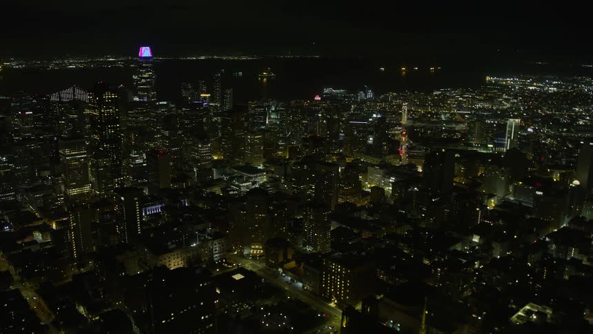  aerial footage showcasing the stunning night view of downtown skyscrapers in San Francisco California as the drone gracefully orbits around the city