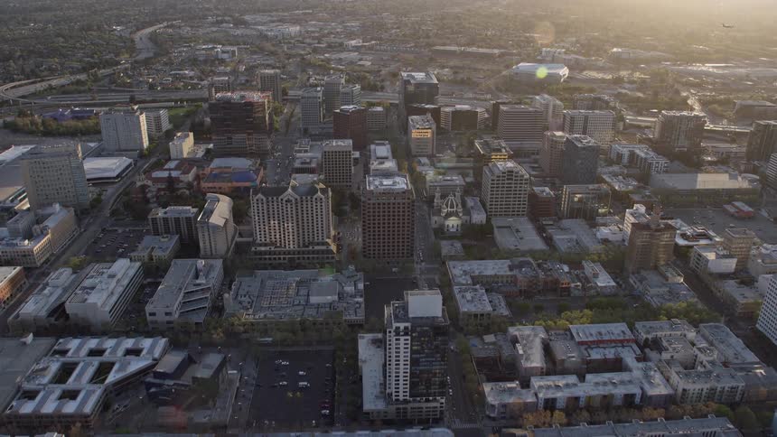  aerial footage of a stunning sunset over Downtown San Jose California featuring office and apartment buildings capturing the essence of the city's bustling downtown area during the summer months