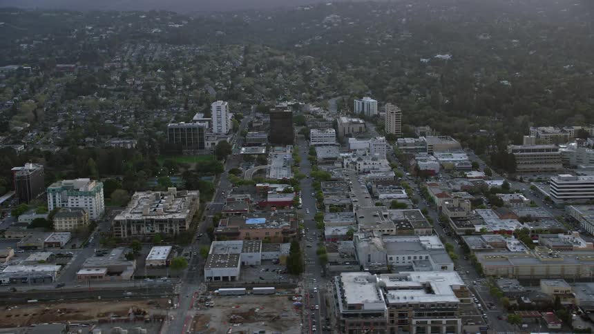  aerial footage showcasing the San Mateo office and apartment buildings during sunset in California's Bay Area capturing the industrial and residential aspects of the city with partly cloudy skies