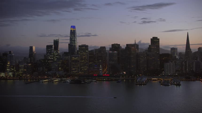  aerial footage capturing the iconic Ferry Building and downtown San Francisco skyline at twilight showcasing the high-rises and cityscape of California's Bay Area