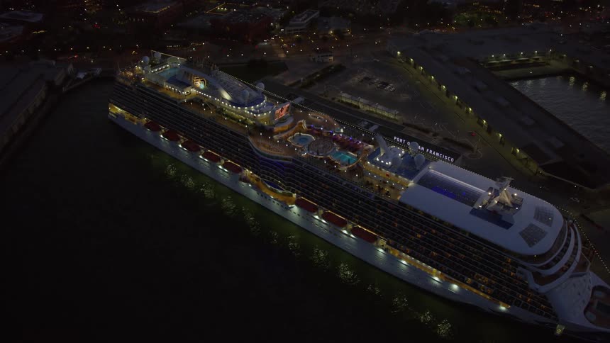 Twilight aerial footage of a cruise ship docked at North Beach San Francisco California with an view of Coit Tower and the iconic city skyline