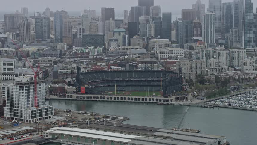 an aerial view of Oracle Park in San Francisco surrounded by fog during a sunny summer day in California