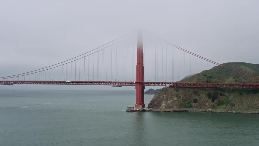  aerial footage captures the foggy daytime flyby of the iconic Golden Gate Bridge on the Marin side showcasing the historic landmark and stunning scenery of San Francisco California