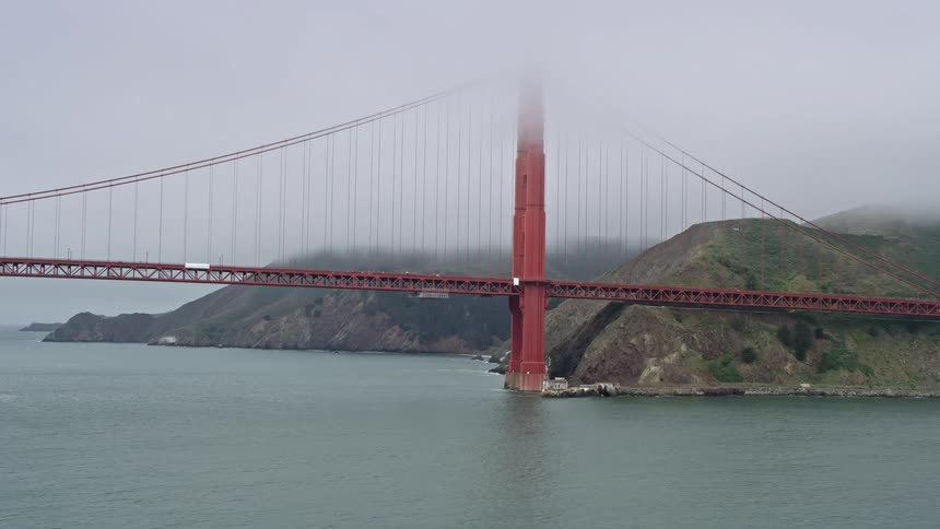 Aerial footage of the fog-covered Marin side of the iconic Golden Gate Bridge shot from a low altitude on a foggy day in San Francisco California