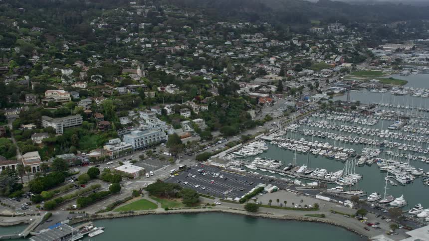  aerial footage of foggy daytime views of homes overlooking marinas in Sausalito California showcasing the beautiful coastline and maritime atmosphere of the San Francisco Bay area