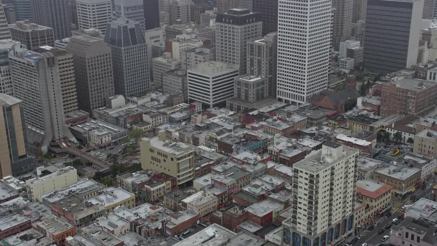Aerial footage of office and apartment buildings in Chinatown San Francisco orbiting on a foggy day in California