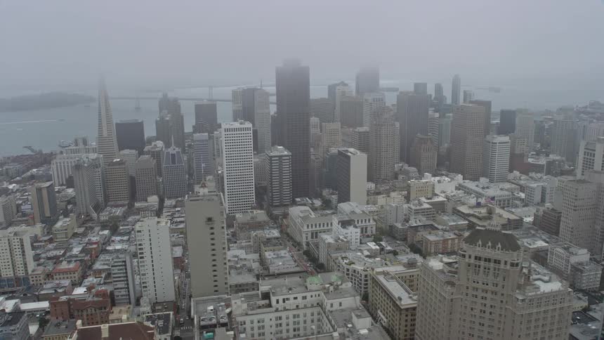  aerial footage of foggy day in downtown San Francisco showcasing the high rise skyscrapers and cityscape of this iconic Northern California city on the West Coast