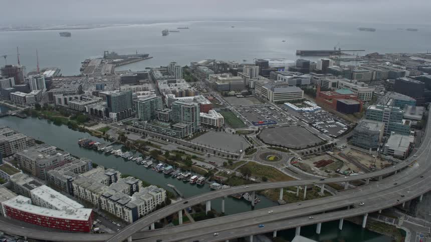  aerial shot of foggy San Francisco showcasing office buildings near an arena on a bustling day