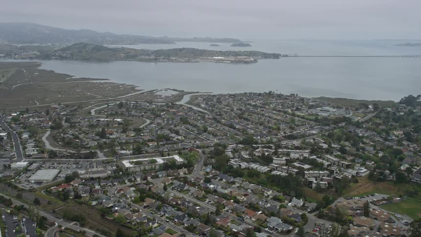 Fly over the suburban neighborhoods of Corte Madera in Northern California on a foggy day with San Quentin State Prison visible in the distance