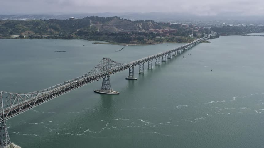  aerial footage of a foggy day flying beside the Richmond Bridge in Northern California's bay area during the spring/summer showcasing the large span of the John F McCarthy Memorial Bridge