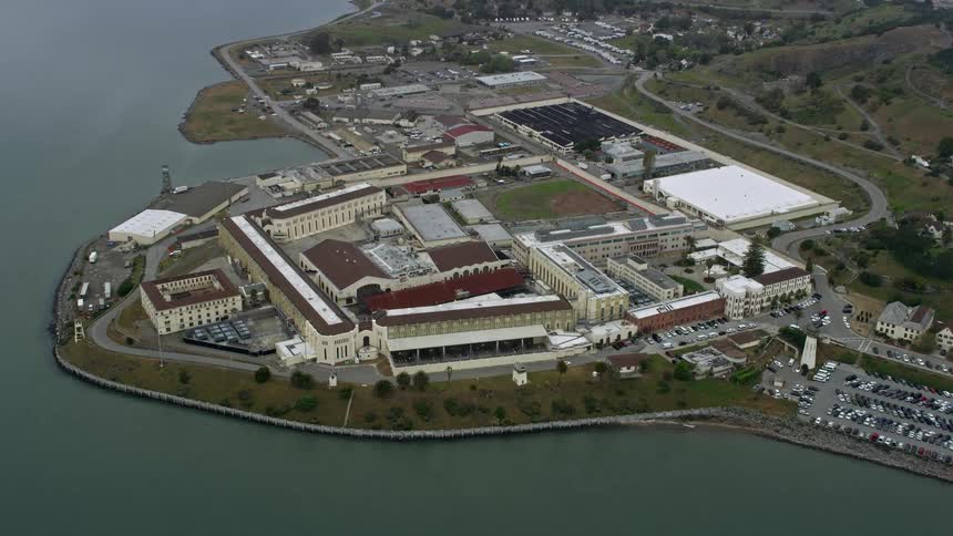 Aerial footage of San Quentin Prison in California approaching and tilting down on the government building
