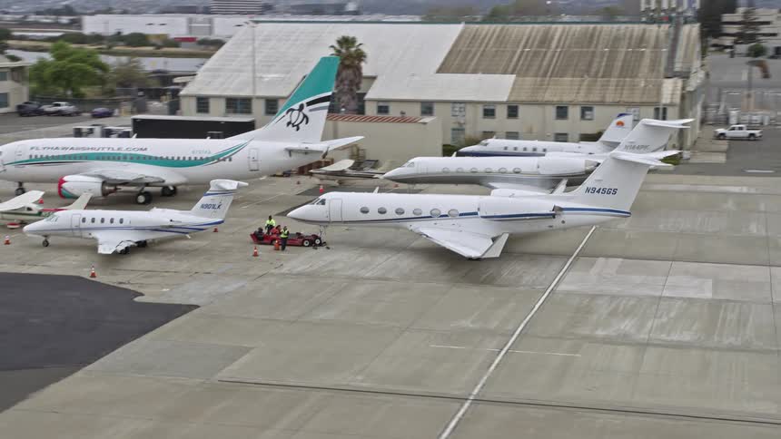  aerial footage of a private jet parked at Oakland Airport California showcasing the airport's large airfield and the beautiful bay area views during the daytime