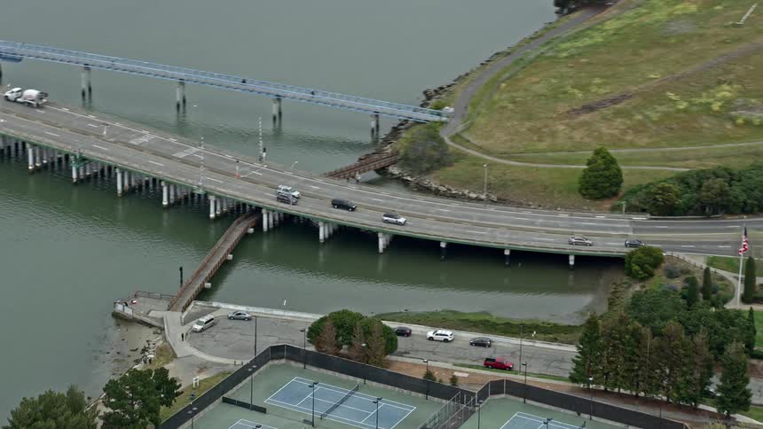 Aerial footage of cars traveling on a small bridge in Alameda California during the daytime