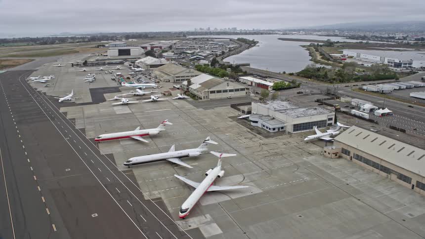  aerial footage of aircraft parked at Oakland Airport California during the day showcasing the bustling airfield and travel hub in the Bay Area