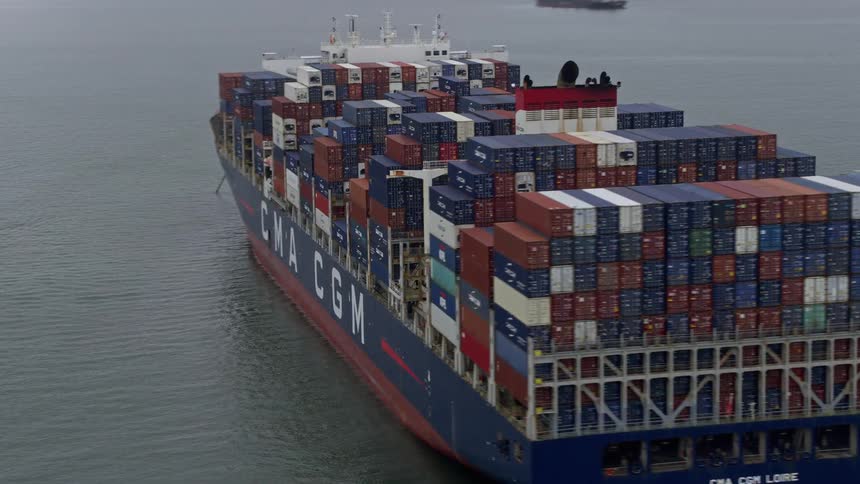  aerial footage of a foggy day in San Francisco Bay California capturing a large cargo ship covered in shipping containers sailing through the bay