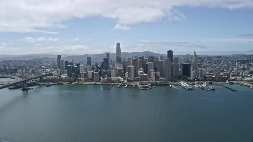anaerial shot of the Downtown San Francisco skyline as seen from San Francisco Bay with high rises skyscrapers and supertalls on a partly cloudy day