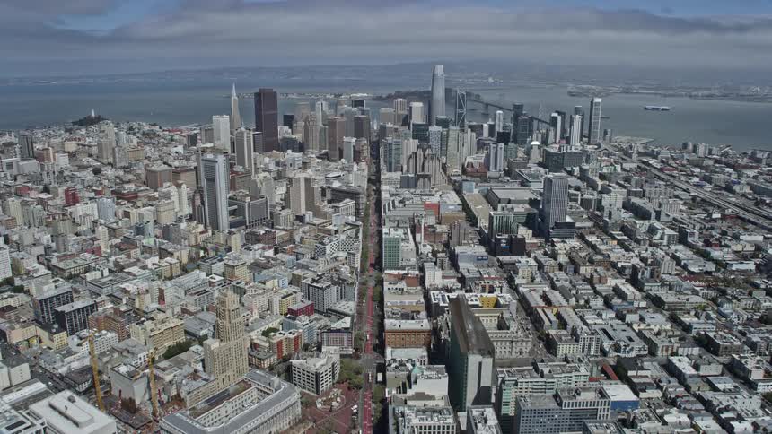 Aerial view of San Francisco's downtown area on Market Street with high rise buildings skyscrapers and a partly cloudy sky during the day