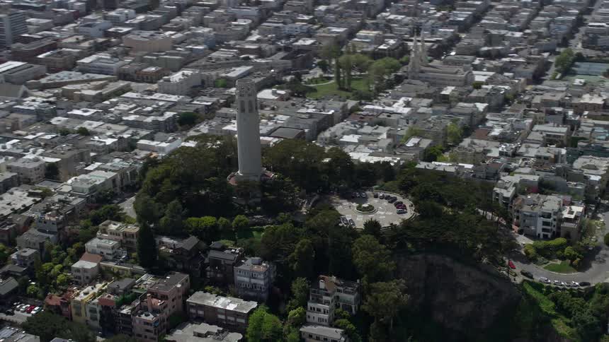  aerial footage of Coit Tower in North Beach San Francisco California showcasing the iconic structure and surrounding cityscape during a partly cloudy day