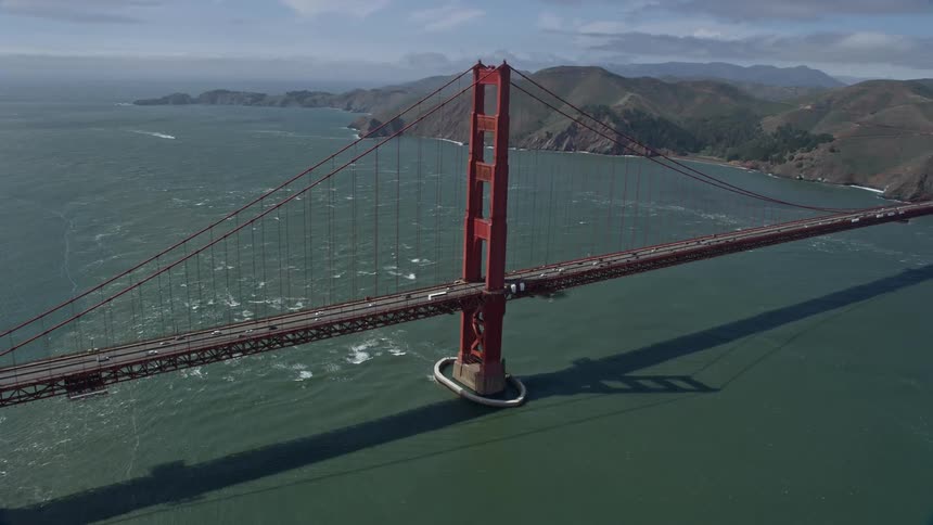  aerial footage capturing a mesmerizing orbit around the iconic Golden Gate Bridge on a partly cloudy day in San Francisco California's historic landmark