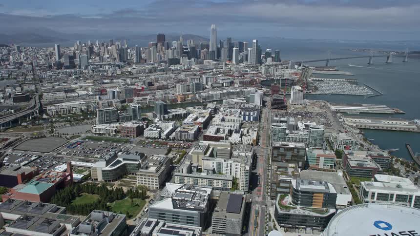  aerial stock footage of flying over South of Market to approach Downtown San Francisco California showcasing the high rise buildings cityscape and iconic Salesforce Tower on a partly cloudy day with a wide-angle view
