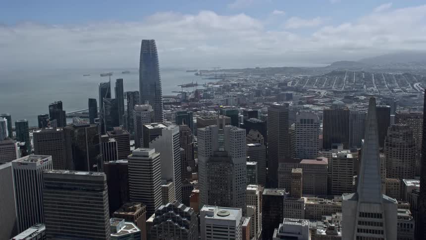 anaerial footage capturing the stunning skyline of Downtown San Francisco as the camera flies over the skyscrapers towards South of Market on a partly cloudy day in California