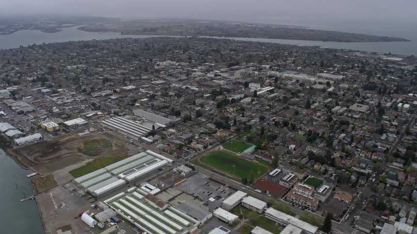 Aerial footage of foggy Alameda residential neighborhoods on a summer day in Northern California approaching the suburban community