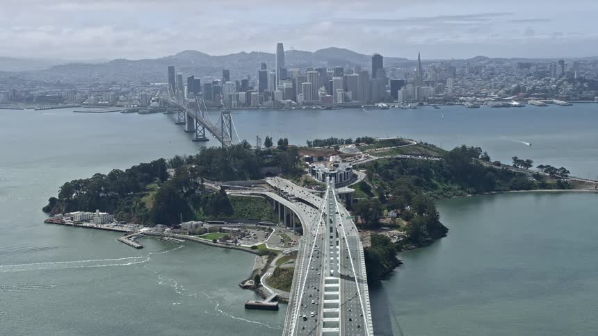  aerial footage of the San Francisco skyline from Yerba Buena Island California showcasing the downtown area bay bridge and partly cloudy skies
