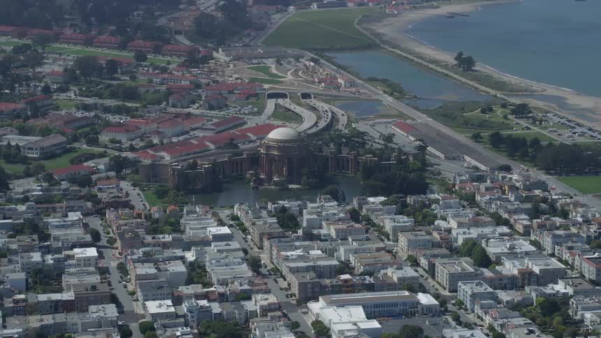  aerial footage of the iconic Palace of Fine Arts in San Francisco California featuring a side view of the historic landmark on a partly cloudy day in the city's marina district
