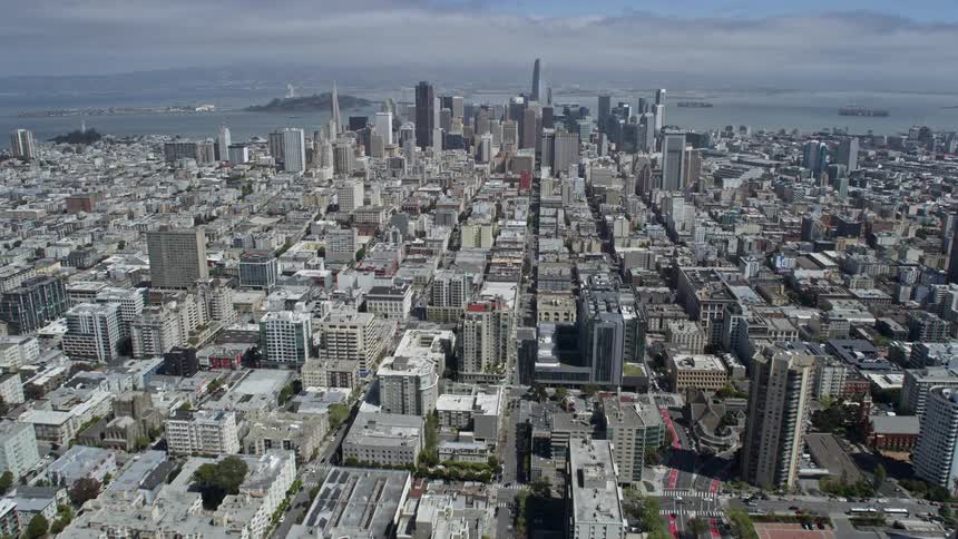 Aerial footage showcases the impressive skyscrapers and downtown area of San Francisco California on a sunny day giving a wide-angle view of the city's urban landscape