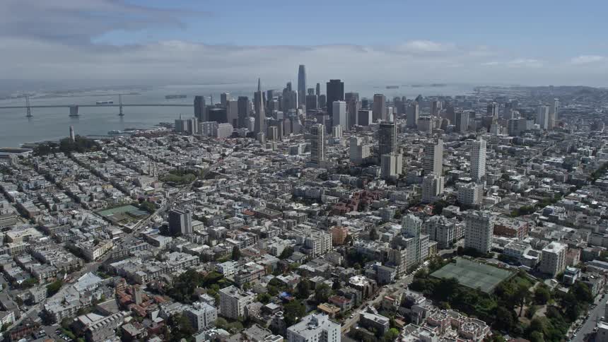  aerial footage showcasing the stunning skyline of Downtown San Francisco viewed from Russian Hill on a partly cloudy day featuring high-rise buildings skyscrapers and the iconic San Francisco Bay area
