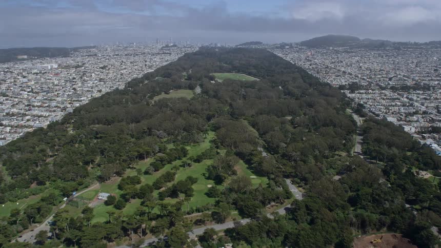  aerial footage of a sunny day flying over Ocean Beach and Golden Gate Park capturing the iconic structures and wide-angle views of San Francisco California's coastal city