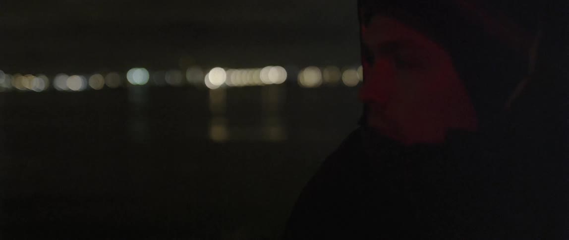 A man wearing a hooded jacket is looking to his right