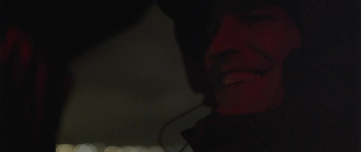 A man is smiling in the dark
